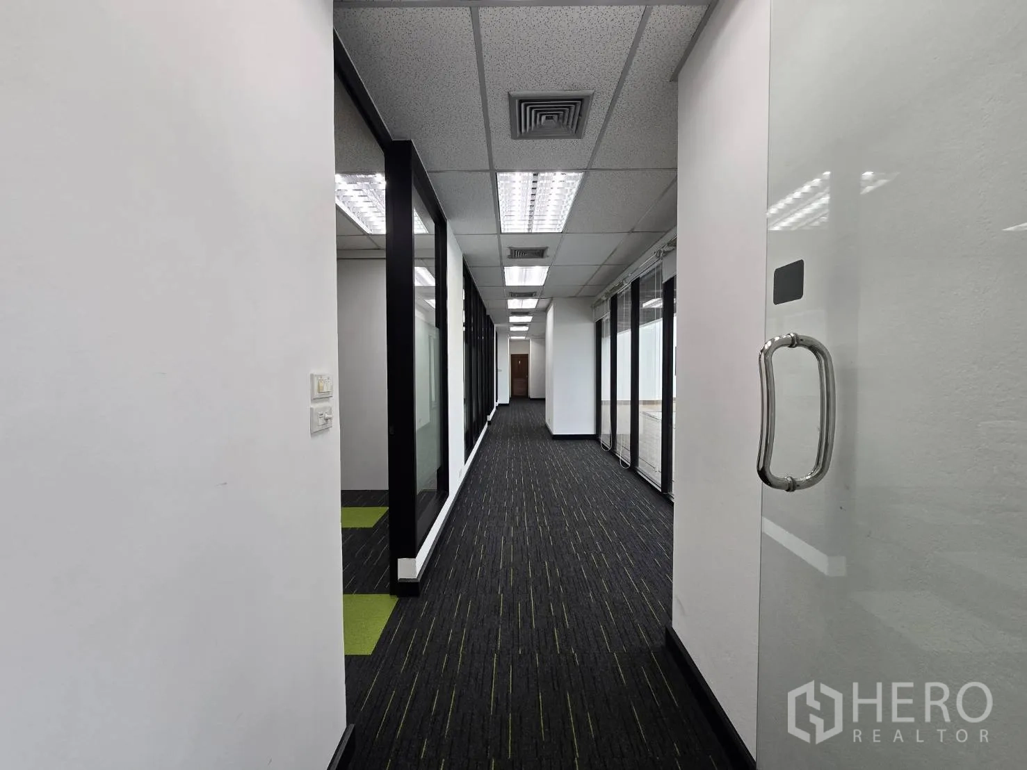 ออฟฟิศ for rent in Watthana, Bangkok - โถงทางเดินสำนักงานยาวกั้นด้วยกระจก ผนังสีขาวและไฟฟลูออเรสเซนต์.