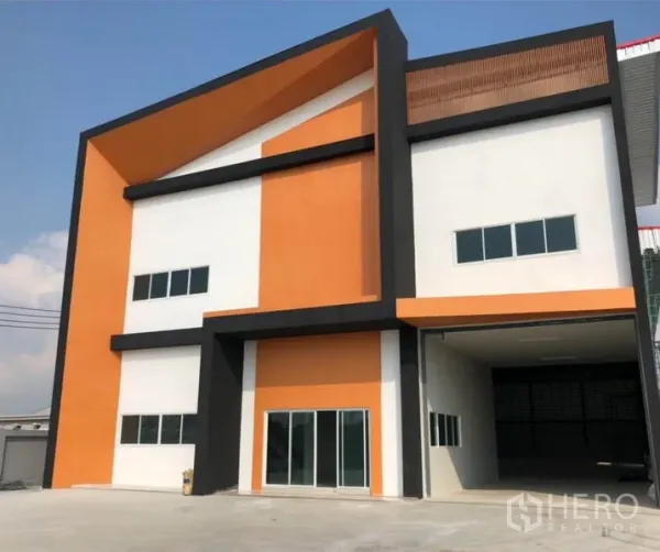 โรงงาน ให้เช่าหรือขายในKrathum Baen, Samut Sakhon - ภาพใกล้ตัวอาคารโรงงานสมัยใหม่ ประตูบานเลื่อนกระจก พื้นที่โหลดสินค้ามีหลังคาสูง และหน้าต่างหลายบาน