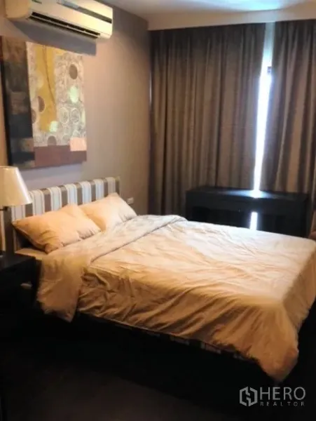 Condominium for rent in Sathon, Bangkok - Cozy bedroom with queen bed, wall art, blackout curtains and air conditioning.