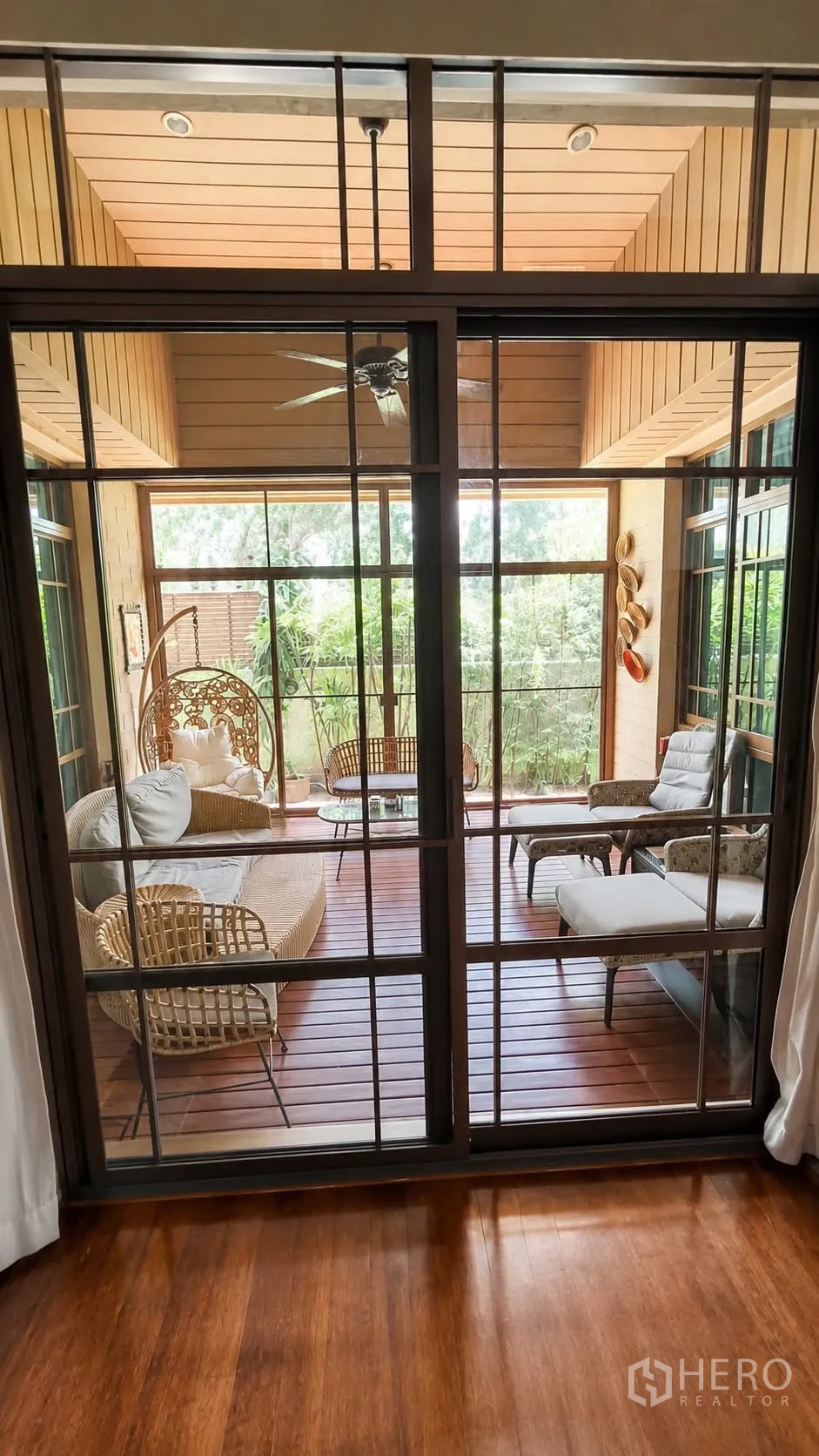 独栋房屋 for rent in Watthana, Bangkok - 封闭式露台设藤编座椅，面向绿意景观。