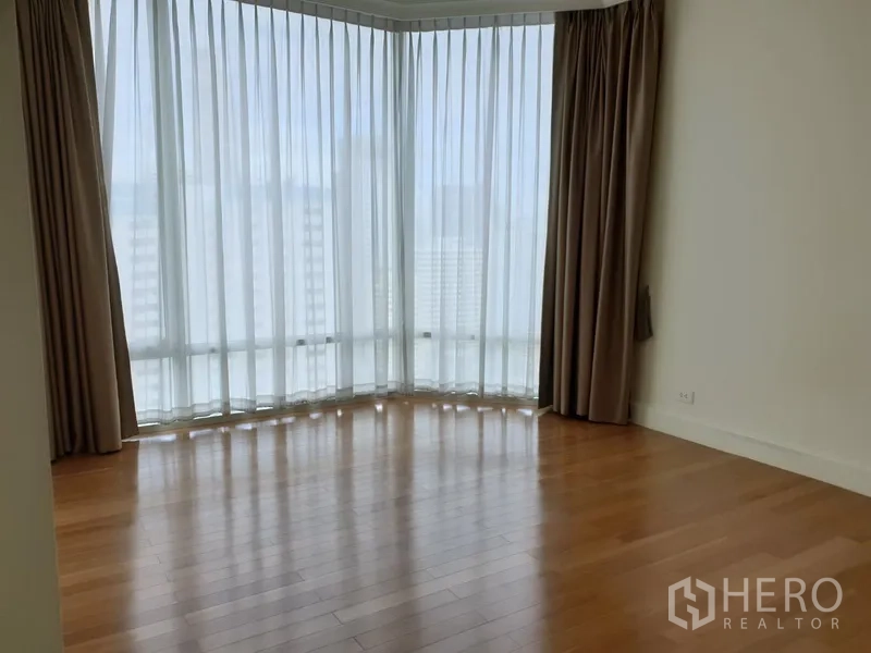 公寓 出租在Watthana, Bangkok - 明亮的转角起居区，落地窗配纱帘与温润木地板，高层曼谷公寓景观。