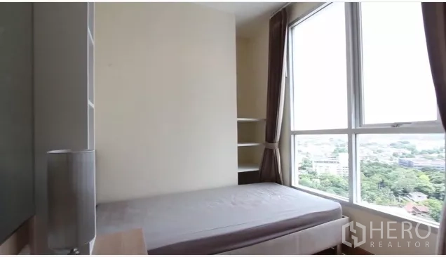 公寓 出租在Watthana, Bangkok - 第二卧室带转角落地窗与开放搁架，视野见绿地。