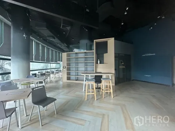 办公空间 出租 - 开放式办公区，鱼骨拼木地板、黑色高挑顶、内置书架与吧台，配大面积卷帘窗。