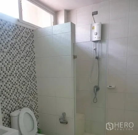 Townhouse for rent or sale in Yan Nawa, Bangkok - Bathroom with mosaic accent wall, glass shower screen and electric water heater.