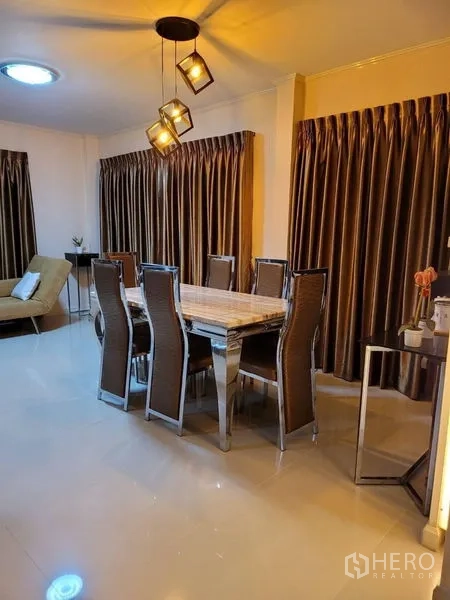 独立式住宅 出租 - 餐区配长桌八椅，现代吊灯与厚窗帘。