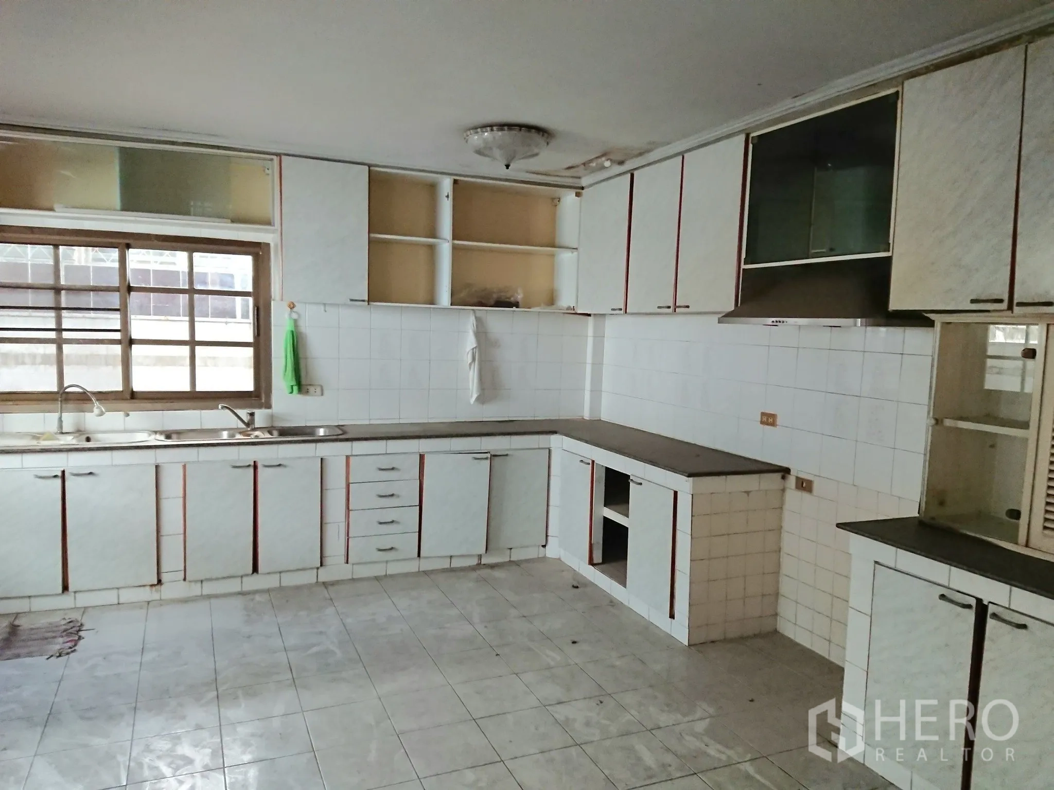 Detached House for sale in Chatuchak, Bangkok - Large Thai kitchen with long counters, cabinets and tiled walls.