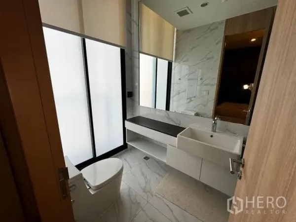 公寓 出租在Watthana, Bangkok - 现代卫浴，磨砂玻璃窗、大理石墙地与悬浮洗手台。