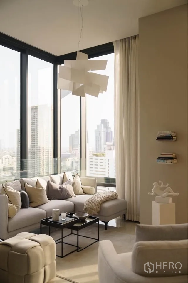 公寓 for rent in Bang Rak, Bangkok - 客厅设转角落地窗、组合沙发与城市天际线景观。