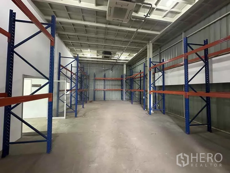 Home Office for rent in Bang Khen, Nonthaburi - Long storage hall fitted with blue-and-orange pallet racks and industrial ceiling AC units.