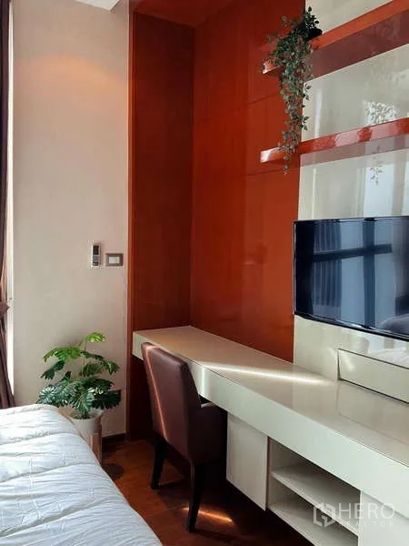 Condominium for rent or sale - Bedroom work desk with wall-mounted TV and storage shelves.