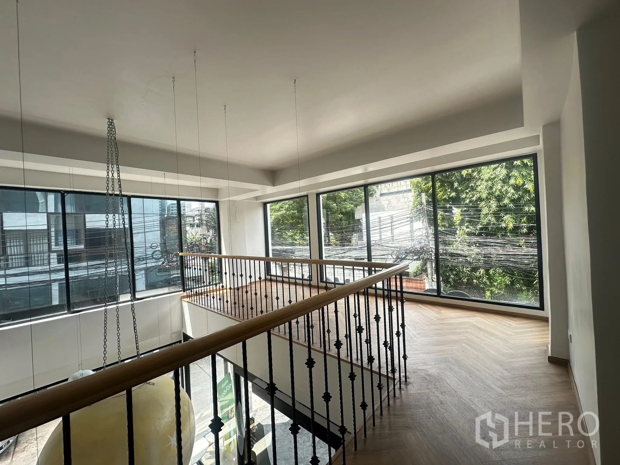 พื้นที่ขายของ for rent in Watthana, Bangkok - ชั้นลอยพร้อมราวกันตกไม้และเหล็ก มีหน้าต่างบานใหญ่เห็นวิวต้นไม้และถนน