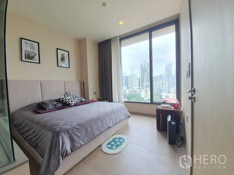 公寓 出租或出售在Watthana, Bangkok - 卧室配大床与落地窗，俯瞰曼谷城市景色。