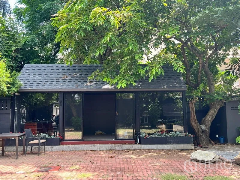 Retail Space for rent in Bangkok - Small standalone glass pavilion shaded by a large tree in the garden.