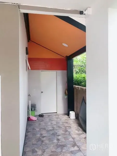 Detached House for sale in Suan Luang, Bangkok - Covered side utility area with tiled floor and orange ceiling beside the house.