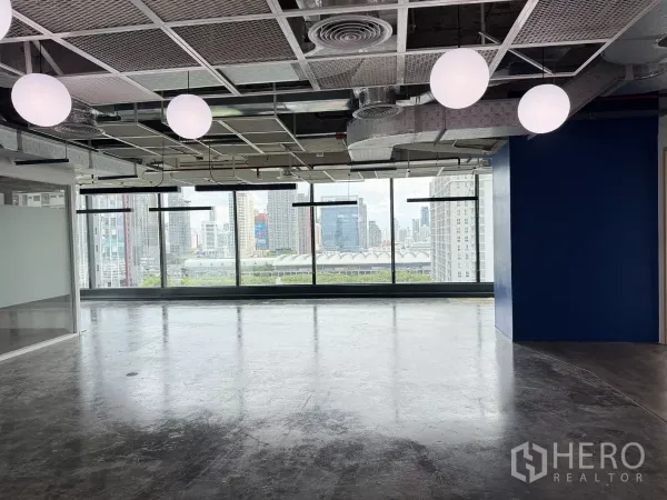 Office Space for rent in Din Daeng, Bangkok - Large open area with globe lights and wide windows framing the Bangkok skyline.