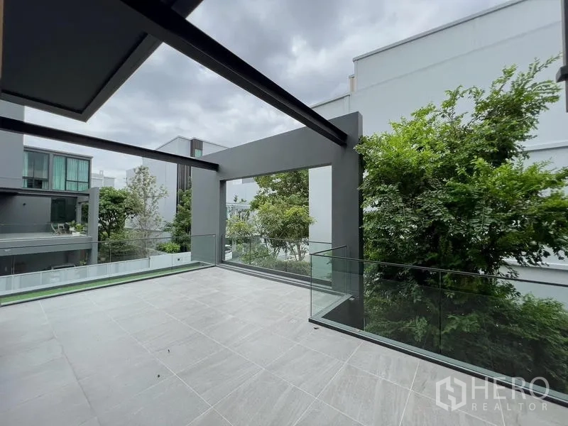 Detached House for rent or sale in Saphan Sung, Bangkok - Expansive terrace with glass balustrade overlooking greenery.