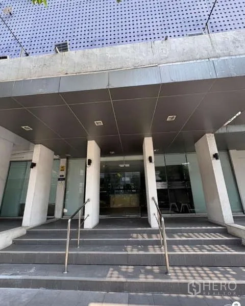 办公空间 出租在Khlong Toei, Bangkok - 三层办公楼主入口，带台阶、立柱与玻璃门（คลองเตย）。