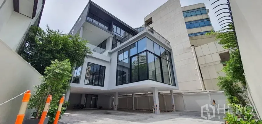 带办公室的家 出租或出售在Watthana, Bangkok - 当代玻璃立面家用办公楼，前方车道与绿植。