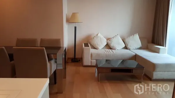 公寓 出租在Ratchathewi, Bangkok - The Address Asoke 明亮客厅，L型沙发、玻璃茶几与落地灯，木地板。