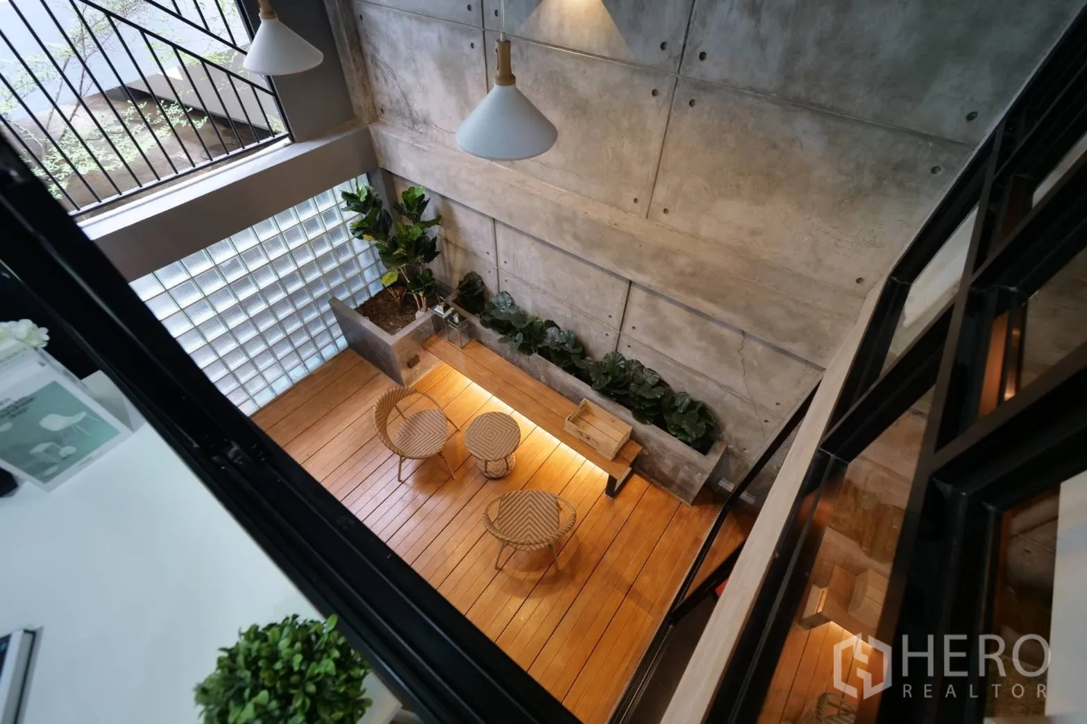 联排别墅 出租在Khlong Toei, Bangkok - 从上方俯瞰的挑空庭院，设花槽和藤椅，木地台。