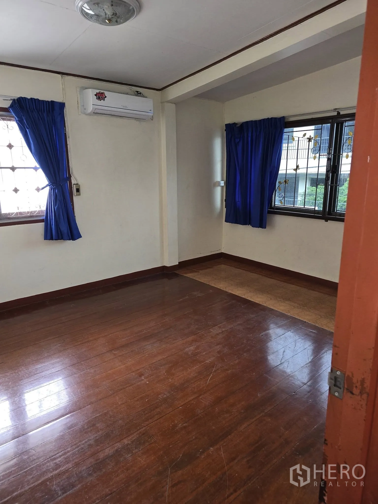 带办公室的家 出租在Wang Thonglang, Bangkok - 转角卧室，木地板，分体空调与两扇窗配蓝色窗帘