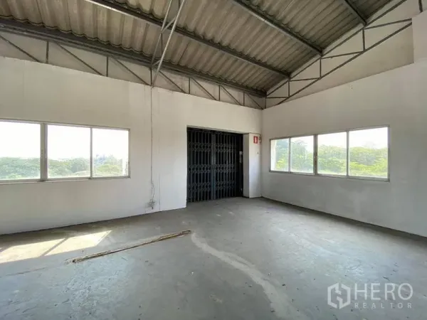 Factory for sale in Bang Phli, Samut Prakan - Bright upper floor area with windows and a gated freight elevator.
