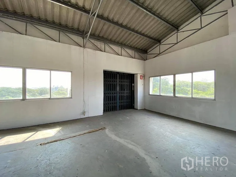Factory for sale in Bang Phli, Samut Prakan - Bright upper floor area with windows and a gated freight elevator.