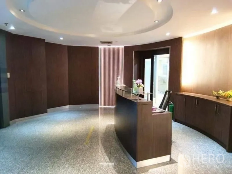 Office Space for rent - Entrance reception area with circular ceiling detail, curved desk and storage credenza.