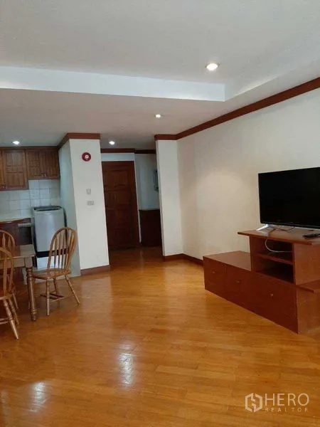 Apartment for rent in Watthana, Bangkok - Spacious living room with TV console facing the dining set and kitchen.