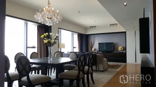 Condominium for rent in Sathon, Bangkok - Bright open-plan dining and living area with chandelier, large windows, and city views in a Sathon condo.