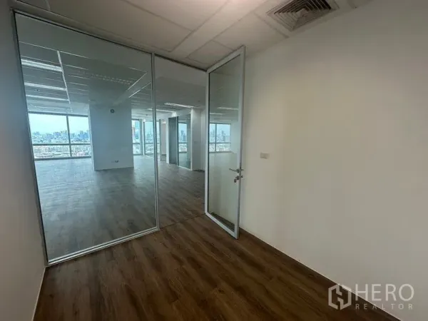 สำนักงาน ให้เช่า - ห้องทำงานส่วนตัวพร้อมประตูกระจกเต็มบาน มองเห็นโถงสำนักงานและวิวเมือง.