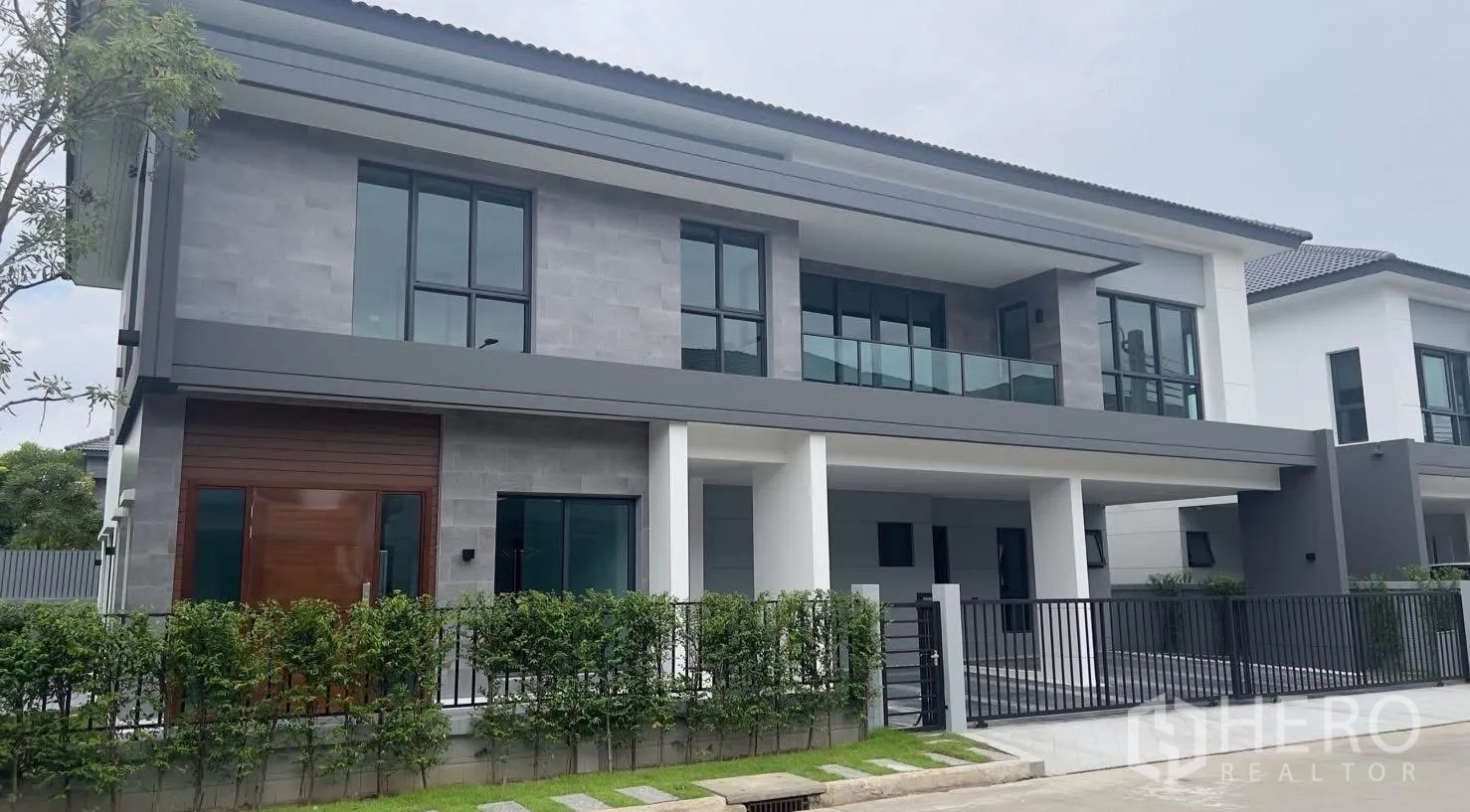 บ้าน ให้เช่าในBang Phli, Samut Prakan - ด้านหน้าบ้านเดี่ยวสองชั้นสมัยใหม่พร้อมรั้วและโรงจอดรถ