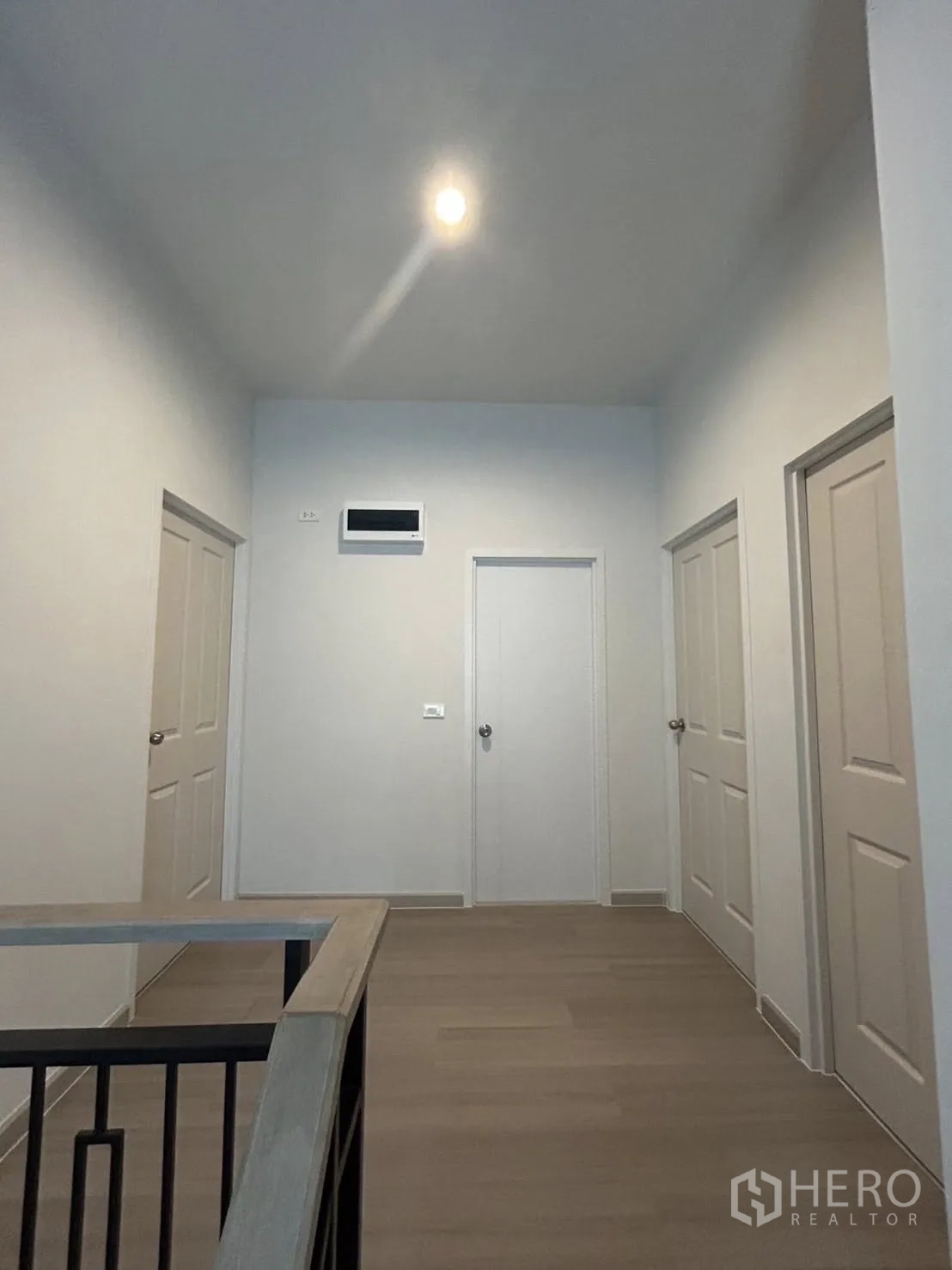 独立式住宅 出租在Khlong Sam Wa, Bangkok - 二层走廊，多间卧室门与木地板