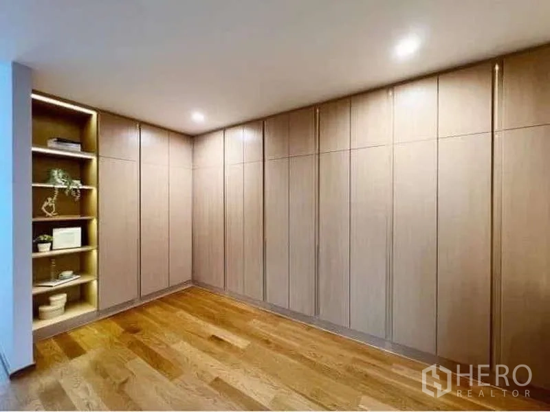 Townhouse for rent or sale in Saphan Sung, Bangkok - Walk-in closet with full-height cabinets and illuminated open shelving.