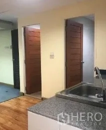 Office Space for rent in Bang Rak, Bangkok - Pantry counter facing two wooden doors leading to utility and bathroom.