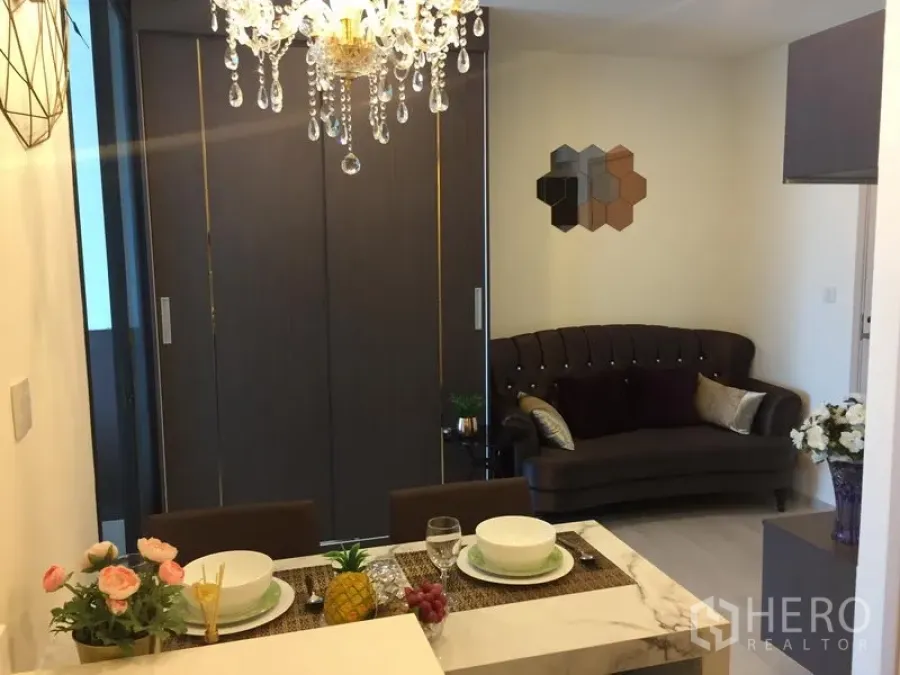 คอนโด ให้เช่าในHuai Khwang, Bangkok - มุมทานอาหารพร้อมโคมระย้า หันหน้าไปยังโซฟาและประตูบานเลื่อนกั้นส่วน