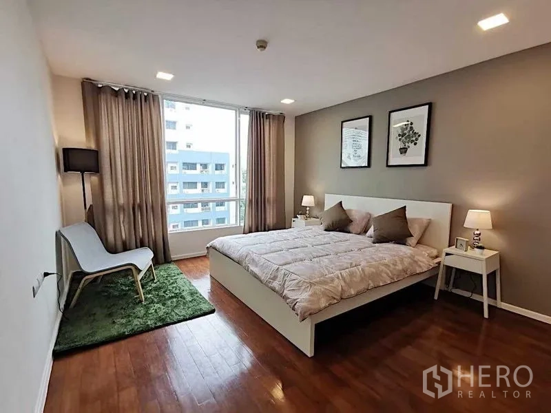 公寓 出售在Khlong Toei, Bangkok - 宽敞卧室，双人床、木地板与大窗户，享城市景观