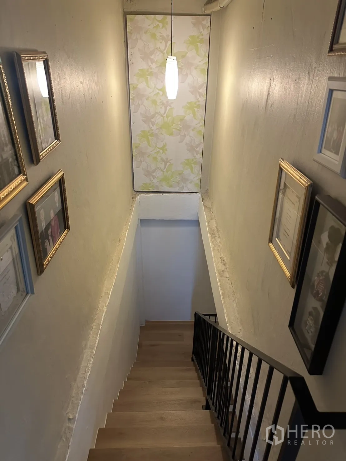 ตึกแถว for sale in Watthana, Bangkok - โถงบันไดแคบมีโคมแขวนและกรอบรูปบนผนัง.