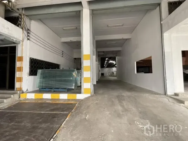 คลังสินค้า ให้เช่าในBang Phli, Samut Prakan - ช่องโหลดสินค้ามีทางลาดขึ้นโกดัง พร้อมเสาแถบสีเหลืองขาวเพื่อความปลอดภัย