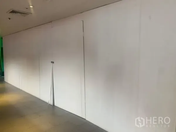 零售空间 出租 - 室内商场走廊旁的空置店铺白色围挡正面