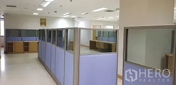 Office Space for rent or sale in Bang Rak, Bangkok - Open-plan office area with blue partitioned cubicles and overhead lighting.