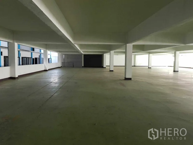 Warehouse for rent in Nong Khaem, Bangkok - Wide warehouse bay with support columns and side windows.