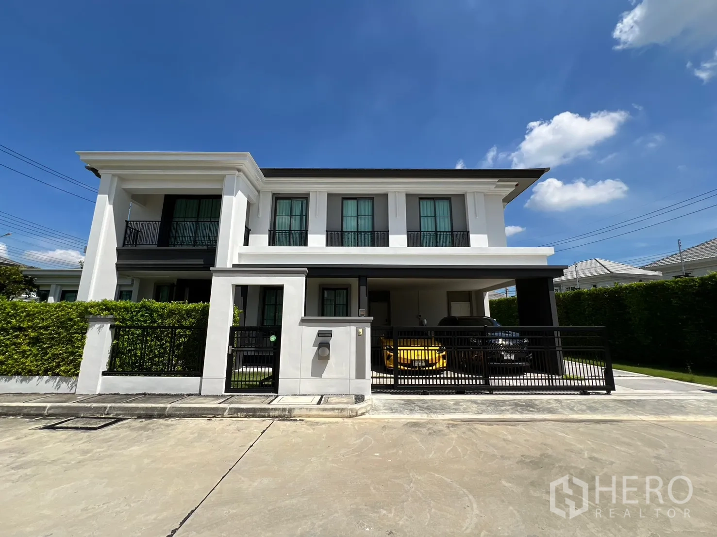独立式住宅 出租或出售在Mueang Pathum Thani, Pathum Thani - 两层独栋住宅正立面，带电动门与遮棚车位。