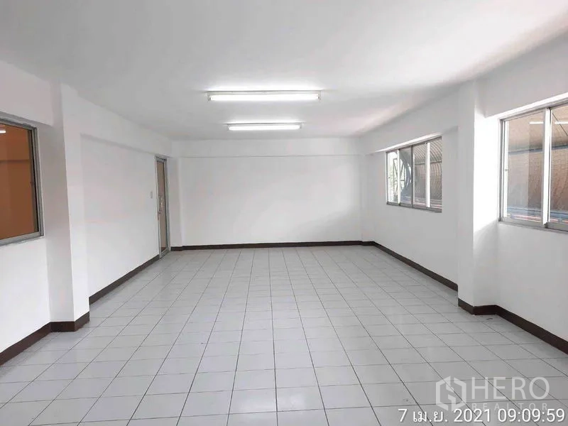 Factory for rent in Bang Bua Thong, Nonthaburi - Bright tiled office room with windows on two sides and fluorescent lighting.