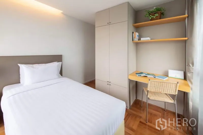Apartment for rent - Guest bedroom with single bed, built-in wardrobe, study desk and wall shelves beside a window.