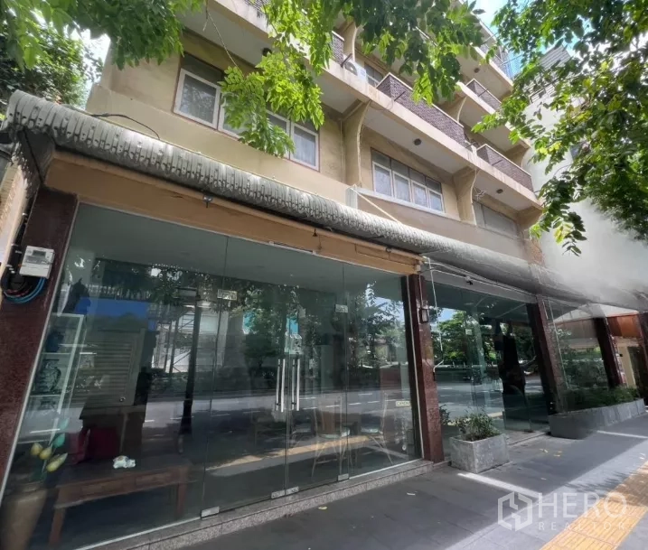 อาคารพาณิชย์ ให้เช่าในWatthana, Bangkok - หน้ากระจกยาวตลอดแนวของร้าน ภายใต้ร่มเงาต้นไม้ริมถนน.