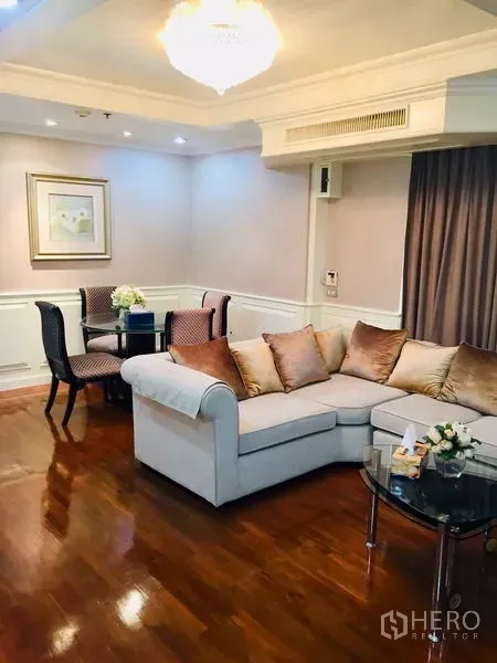 คอนโด ขายในWatthana, Bangkok - ห้องนั่งเล่นอบอุ่น โซฟาเข้ามุม โคมระย้า พื้นไม้ และชุดรับประทานอาหารเล็ก