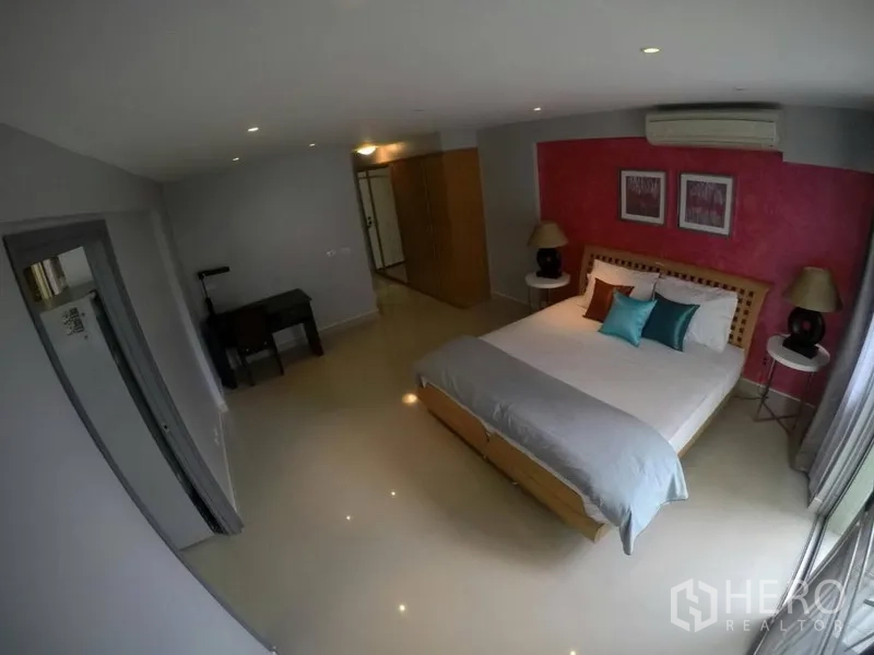 Condominium for rent in Watthana, Bangkok - Spacious second bedroom with red accent wall, desk and large window.