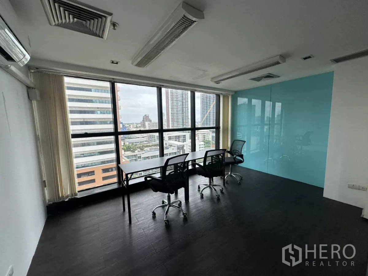 Office Space for rent in Watthana, Bangkok - Bright meeting room with blue feature wall, three chairs and panoramic windows.