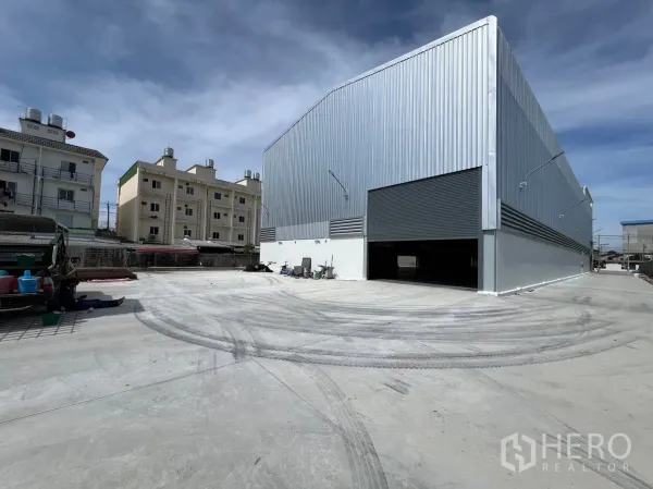 Warehouse for rent in Bang Sao Thong, Samut Prakan - New steel-clad warehouse exterior with large roller shutter and wide concrete yard in Bang Sao Thong, Samut Prakan.
